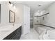 Bathroom showcasing double vanity sinks, walk-in closet, and a tiled shower at 2990 S Juliet Ct, Strasburg, CO 80136