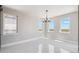 Bright dining room featuring tile floors, a modern chandelier, and large windows at 2990 S Juliet Ct, Strasburg, CO 80136