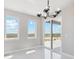 Bright dining room with tile floors, modern chandelier and sliding glass doors at 2990 S Juliet Ct, Strasburg, CO 80136