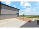 Side exterior of a home with neutral paint, gravel landscaping, and a concrete driveway at 2990 S Juliet Ct, Strasburg, CO 80136