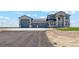 Stunning two-story home featuring a three-car garage and stone detailing under a blue sky at 2990 S Juliet Ct, Strasburg, CO 80136