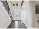 Bright foyer with dark hardwood floors, white doors, a modern staircase and an elegant chandelier at 2990 S Juliet Ct, Strasburg, CO 80136