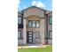 Stunning front entrance with a stone pillar archway, black framed windows, and trimmed green lawn at 2990 S Juliet Ct, Strasburg, CO 80136
