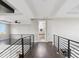 Hallway with hardwood floors and railing leading to an opening with a bathroom at 2990 S Juliet Ct, Strasburg, CO 80136