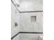 This bathroom features a walk-in shower with gray, modern tiling and a built-in niche at 2990 S Juliet Ct, Strasburg, CO 80136