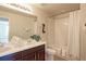 Well-lit bathroom featuring double sink vanity, decorative mirror and shower with bathtub at 4783 S Wenatchee Cir, Aurora, CO 80015