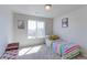 Bright bedroom with large window offers carpet floors, bench and charming decoration at 4783 S Wenatchee Cir, Aurora, CO 80015