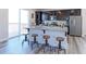 Kitchen with a large island, stainless steel appliances, dark cabinets, and sliding glass doors to outdoor space at 4783 S Wenatchee Cir, Aurora, CO 80015