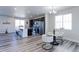 Open-concept kitchen and dining area with stainless steel appliances, modern light fixtures, and stylish wood floors at 4783 S Wenatchee Cir, Aurora, CO 80015
