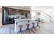 Spacious kitchen with dark cabinets, island with barstool seating, and stainless steel appliances, opening to dining area at 4783 S Wenatchee Cir, Aurora, CO 80015