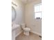 Cozy powder room with a pedestal sink, toilet, and a small window providing natural light at 4783 S Wenatchee Cir, Aurora, CO 80015