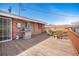 Back deck of a brick home with a grill, seating, and sliding glass door for easy access to the interior at 16805 W 16Th Pl, Golden, CO 80401