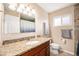Bathroom with granite countertop, wood cabinets, decorative mirror, and tiled wall accent at 16805 W 16Th Pl, Golden, CO 80401
