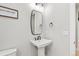 Clean, half bathroom with a pedestal sink, toilet, and mirror at 423 Rogers Way, Castle Rock, CO 80104