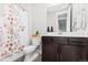 Cozy bathroom with a floral shower curtain, dark vanity and mirror, and a modern toilet at 423 Rogers Way, Castle Rock, CO 80104
