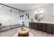 Contemporary bathroom featuring a walk-in shower, dual shower heads, and a large vanity with a round mirror at 423 Rogers Way, Castle Rock, CO 80104