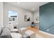 Stylish living room features a modern accent wall, a sofa and a bright window at 423 Rogers Way, Castle Rock, CO 80104