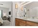 Bright bathroom featuring double sinks, wooden cabinetry, and view to bedroom at 23346 E 5Th Pl # 101, Aurora, CO 80018