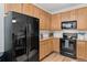 Kitchen features black appliances, light wood cabinets, and ample counter space at 23346 E 5Th Pl # 101, Aurora, CO 80018