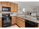 Well-equipped kitchen with black appliances, plenty of counter space, and wood cabinetry at 23346 E 5Th Pl # 101, Aurora, CO 80018
