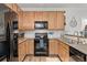 Well-lit kitchen with black appliances, light wood cabinetry, and granite countertops at 23346 E 5Th Pl # 101, Aurora, CO 80018