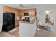 Modern kitchen with sleek black appliances, wooden cabinets, and a pass-through to the living area at 23346 E 5Th Pl # 101, Aurora, CO 80018