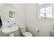 Well-lit half bathroom with a pedestal sink, an oval mirror and a window at 2520 Canfield Ln, Erie, CO 80026