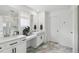 Bright bathroom featuring double sinks, vanity, modern fixtures, and stylish geometric flooring at 2520 Canfield Ln, Erie, CO 80026