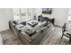 Bright living room featuring a sectional sofa, media console, hardwood floors, and backyard views at 2520 Canfield Ln, Erie, CO 80026