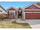 Cozy single-Gathering home with a red exterior, complemented by stone accents and well-maintained front yard at 13756 Legend Trl # 101, Broomfield, CO 80023