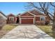 Charming single-Gathering home featuring a two-car garage, red siding and stone accents at 13756 Legend Trl # 101, Broomfield, CO 80023