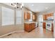 Well-lit kitchen with tile flooring, wood cabinets and white appliances at 13756 Legend Trl # 101, Broomfield, CO 80023