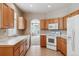 Bright kitchen featuring wood cabinets, white appliances and tile floors at 13756 Legend Trl # 101, Broomfield, CO 80023