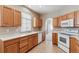 Functional kitchen featuring wood cabinets, white countertops and appliances at 13756 Legend Trl # 101, Broomfield, CO 80023