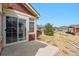 Back patio of home with sliding glass doors, stone landscaping, and lush yard at 13756 Legend Trl # 101, Broomfield, CO 80023