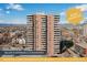 Multi-story condominium building with balcony views of the city skyline and mountain range under a bright blue sky at 130 N Pearl St # 1606, Denver, CO 80203