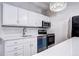 Kitchen featuring stainless steel appliances, elegant white cabinetry, and quartz countertops and plenty of natural light at 130 N Pearl St # 1606, Denver, CO 80203