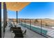 Open-air balcony with comfortable seating offers panoramic views of the adjacent fields and community at 4273 Ridgewalk Pt, Castle Rock, CO 80108