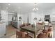 Open floorplan dining area adjoining a modern kitchen with stainless steel appliances and island seating at 4273 Ridgewalk Pt, Castle Rock, CO 80108