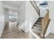 Hallway view of kitchen, dining, and stairs featuring light-colored walls, luxury vinyl plank, and carpeted stairs at 4273 Ridgewalk Pt, Castle Rock, CO 80108