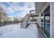 Backyard featuring a small balcony, stairs leading to the yard and a snow covered landscape at 10510 Berthoud Way, Parker, CO 80134