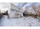 Home exterior featuring a backyard with a wooden fence, a lawn covered in snow and an elevated balcony at 10510 Berthoud Way, Parker, CO 80134