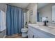 Bright bathroom with white vanity, framed mirror, and shower with a stylish blue curtain at 10510 Berthoud Way, Parker, CO 80134