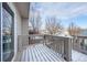 Balcony covered in snow with wood railings and a view of the wintery neighborhood at 10510 Berthoud Way, Parker, CO 80134