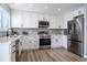 Bright kitchen featuring white cabinets, stainless steel appliances, and stylish gray subway tile backsplash at 10510 Berthoud Way, Parker, CO 80134