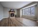 Living room features wood floors, a brick fireplace, a large window, and neutral paint at 10510 Berthoud Way, Parker, CO 80134