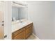 Half-bathroom with a sink, mirror, and wood cabinets at 12912 Grant Cir # A, Thornton, CO 80241