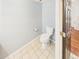 Powder room with a tiled floor, toilet, and an entry door at 12912 Grant Cir # A, Thornton, CO 80241