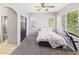 Cozy bedroom with carpet, two windows, a black door, and a glimpse of the bathroom at 12912 Grant Cir # A, Thornton, CO 80241