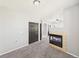 Carpeted bedroom with fireplace, black doors, and a view into the adjoining bathroom at 12912 Grant Cir # A, Thornton, CO 80241